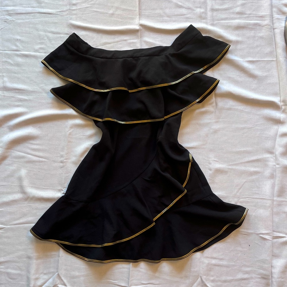 Mini off shoulder black dress with golden outlined ruffles.